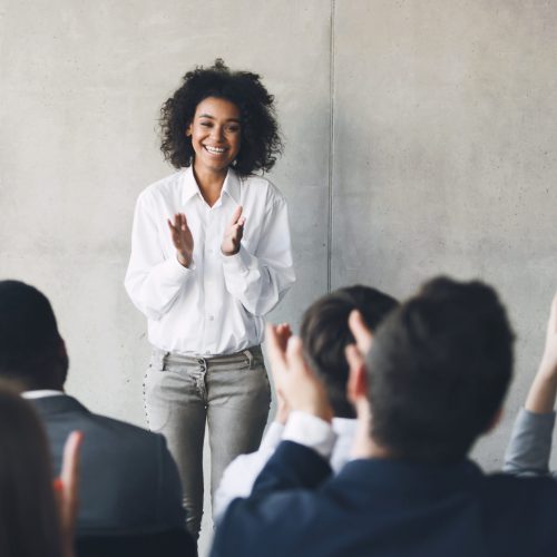 Business presentation. Grateful audience clapping hands to speaker after informative training